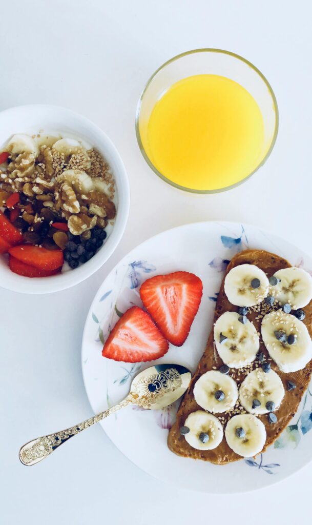 Nutritious breakfast with banana toast, fruit bowl, and orange juice, perfect for a healthy start.